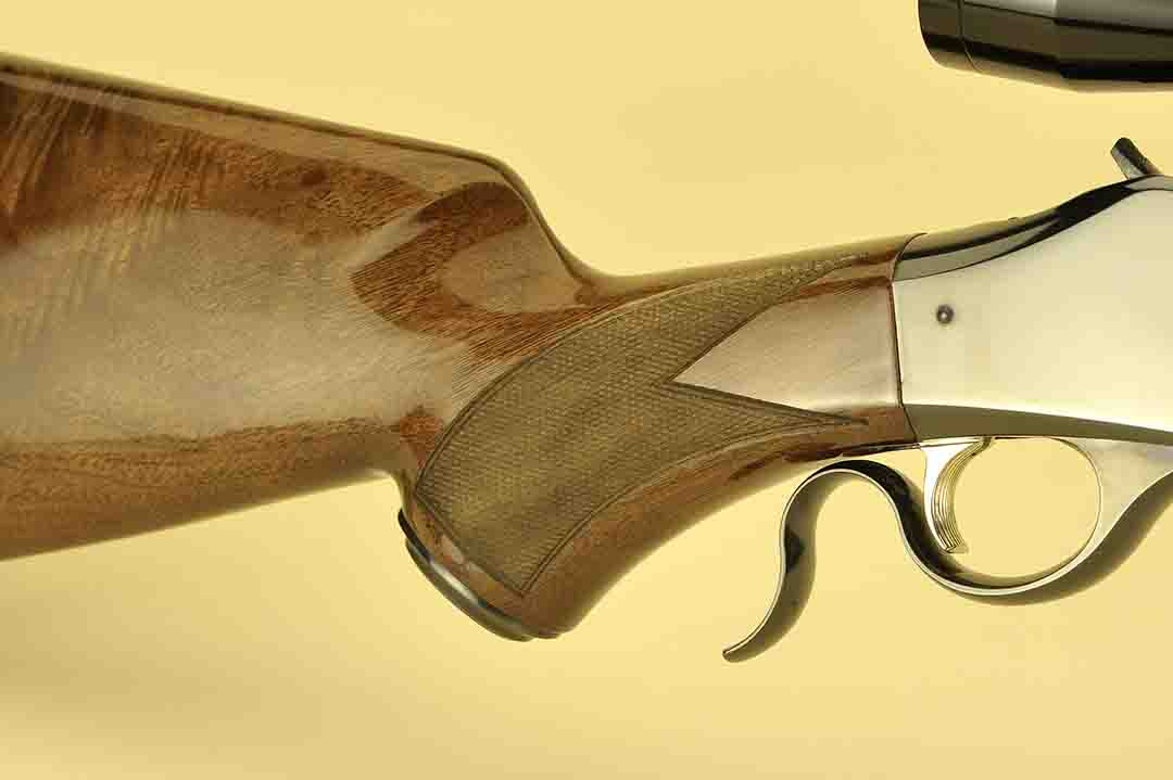 This is a close-up of the underlever on this High Wall rifle with its graceful curve. Fine line checkering is part of the gun, complete with a border for that custom look.